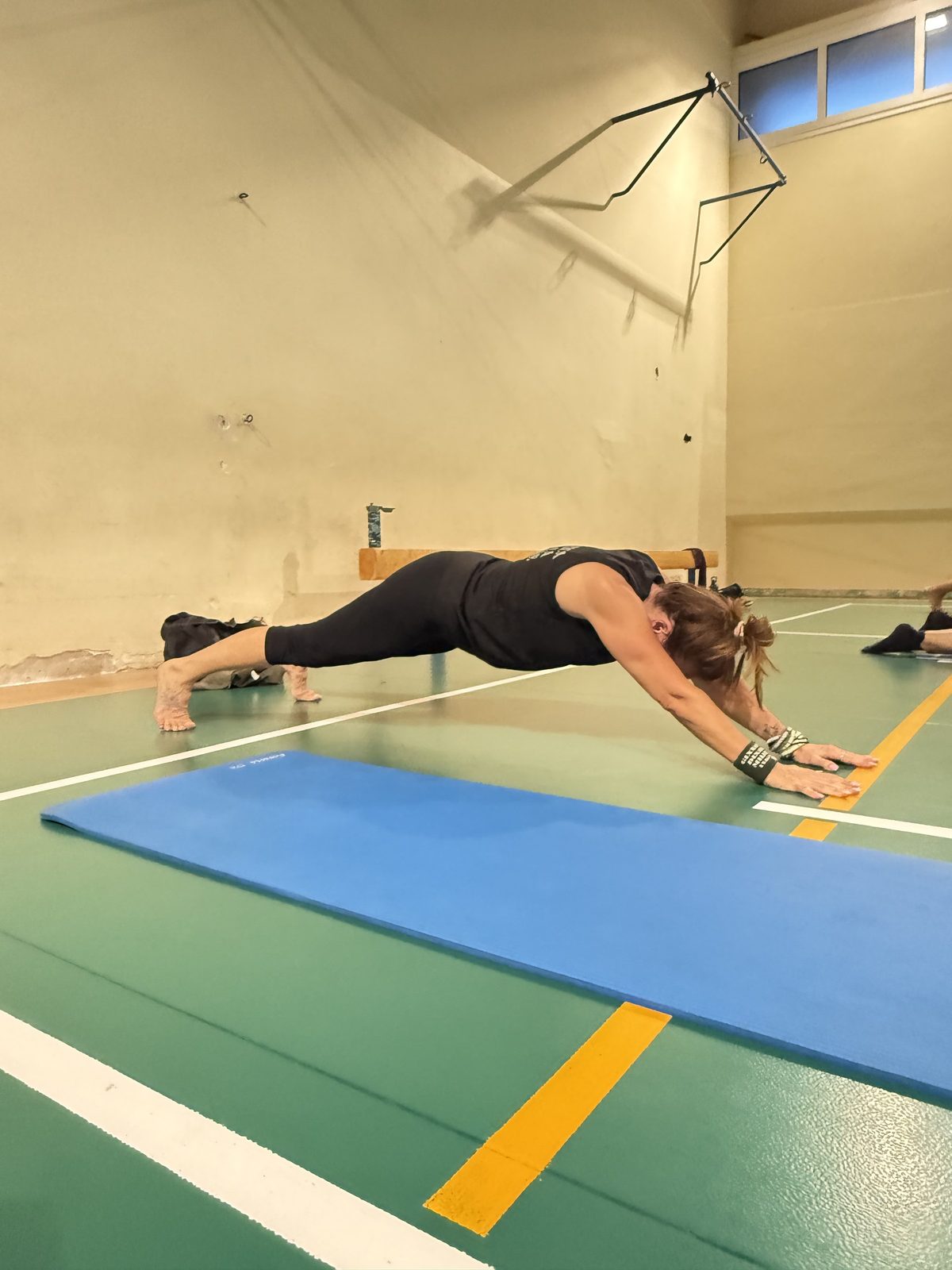 Atleta in plank sul pavimento della palestra, GDM Malnate